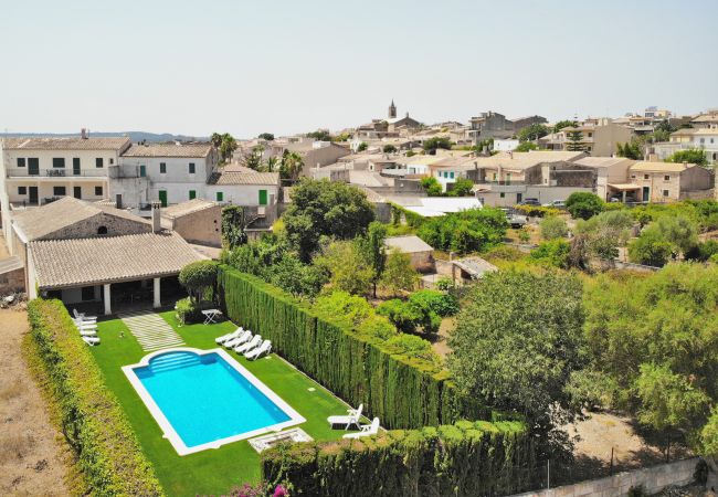 Blick auf das Schwimmbad der Villa Tofollubi mit dem Dorf Llubi.